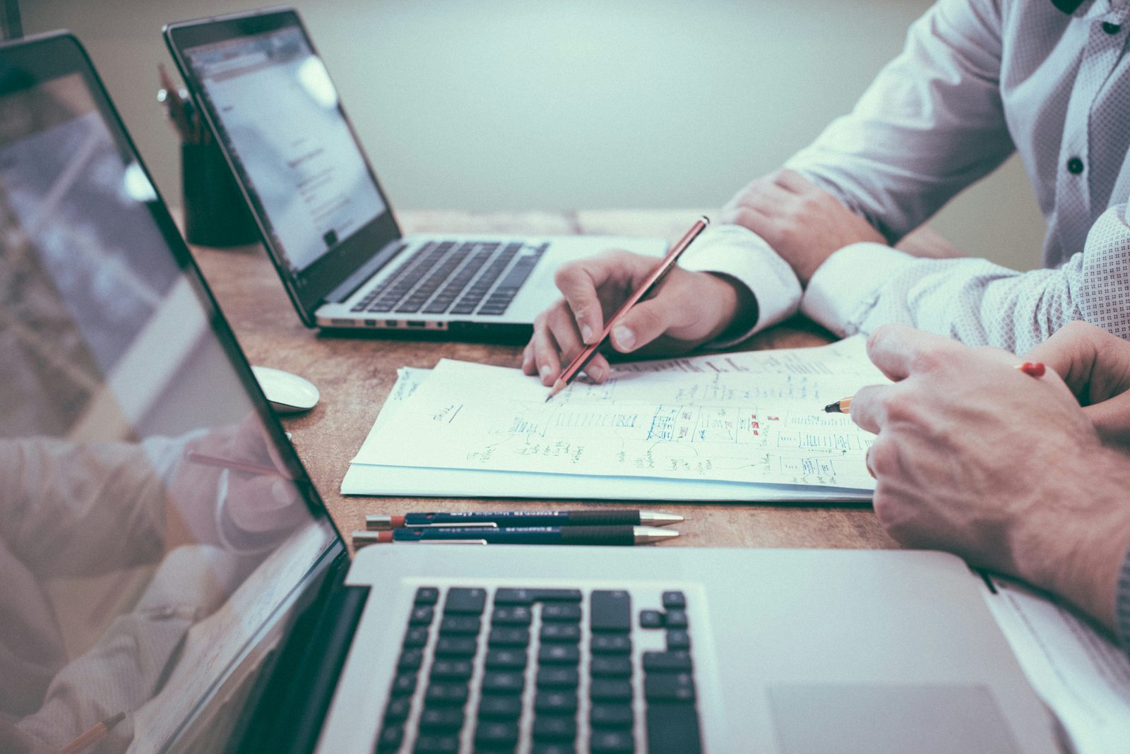 Duas pessoas a analisar documentos com números sobre a mesa