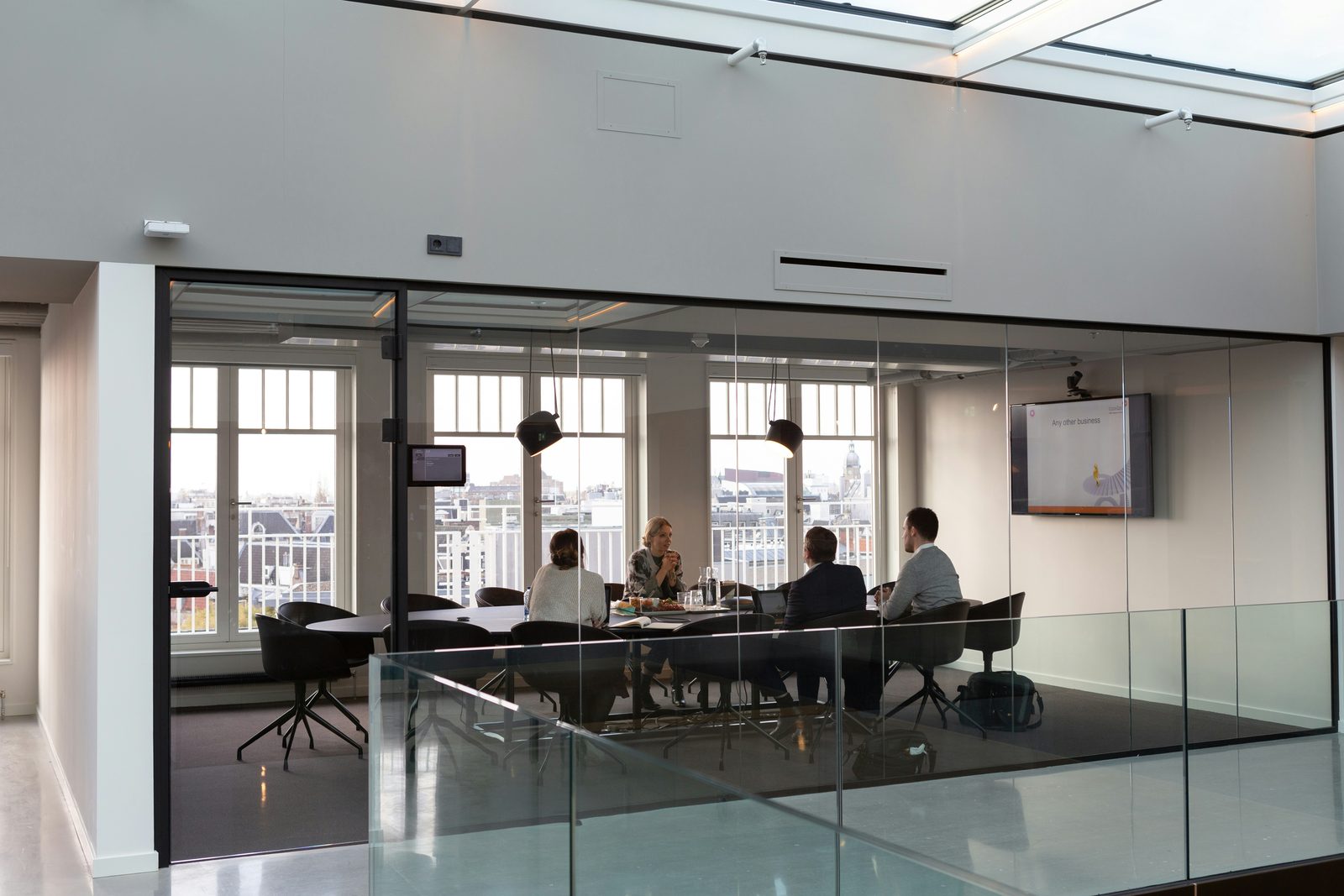 Reunião de trabalho vista do exterior de uma sala envidraçada